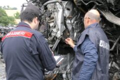 Carabinieri verificano carcasse auto pressate durante perquisizione impianto autodemolizione